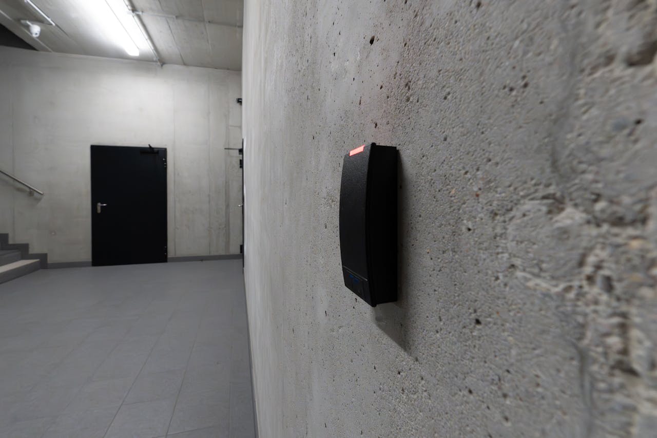 A smart electronic access terminal mounted on a concrete wall in an industrial interior for enhanced security.